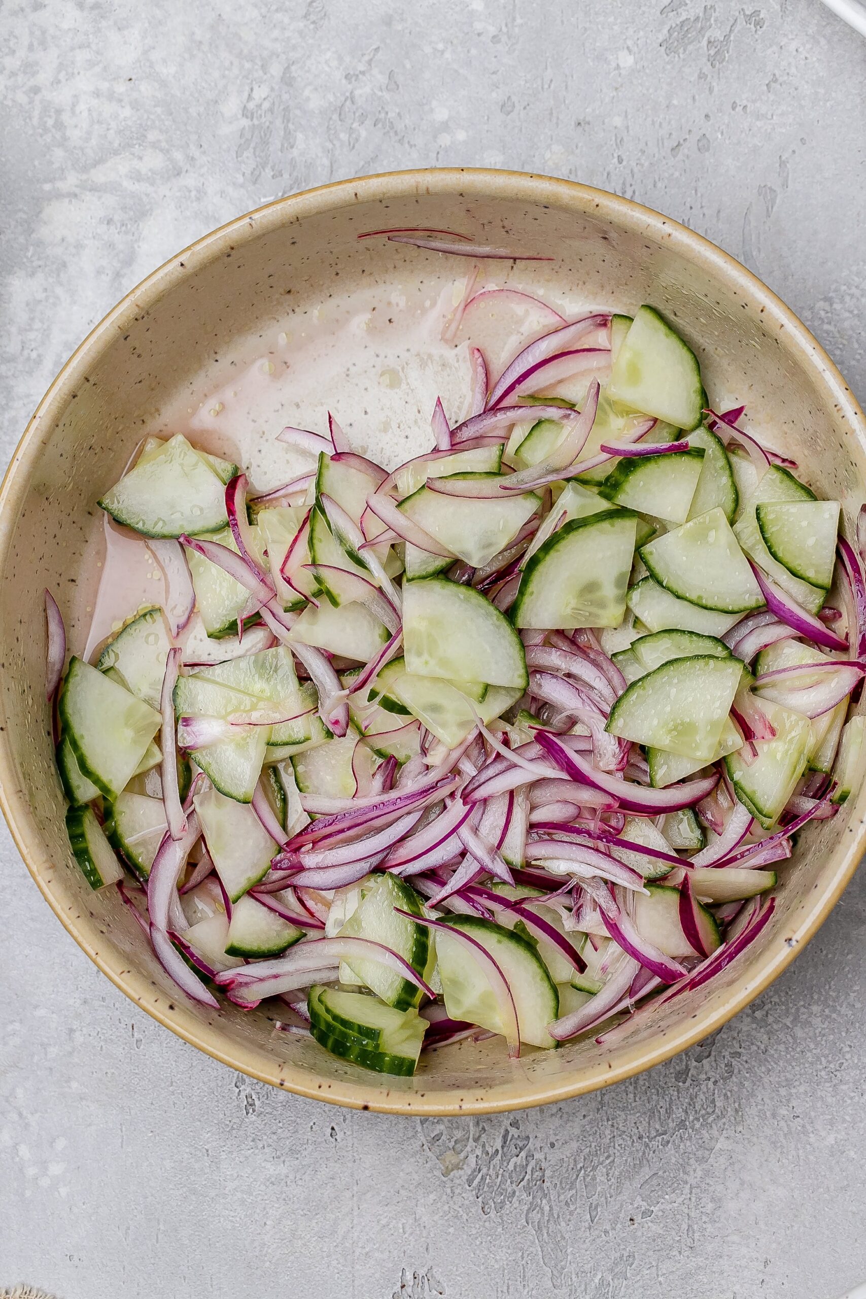 cucumber and red onion salad in bowl.