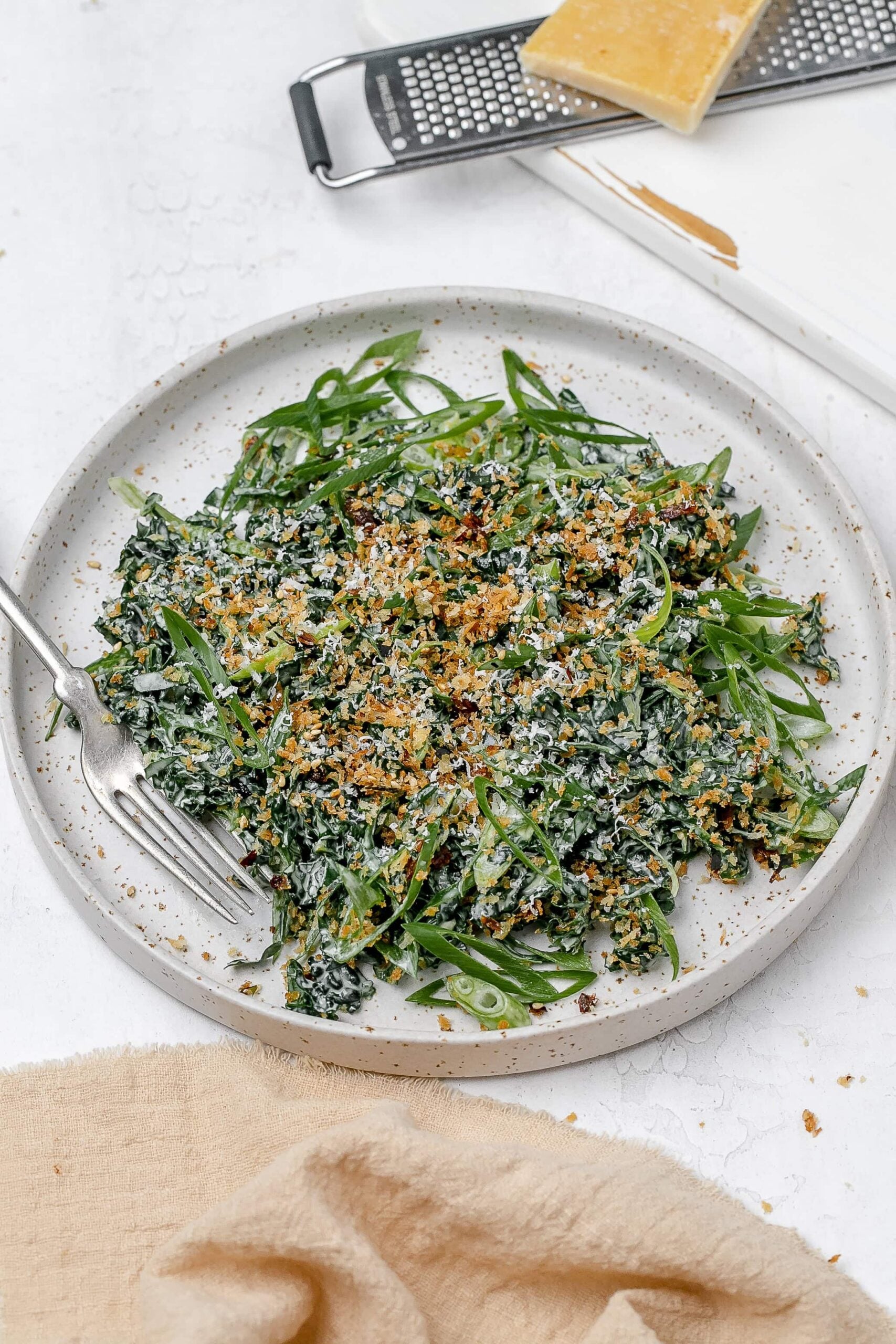 Miso kale caesar salad on a plate with a fork. 