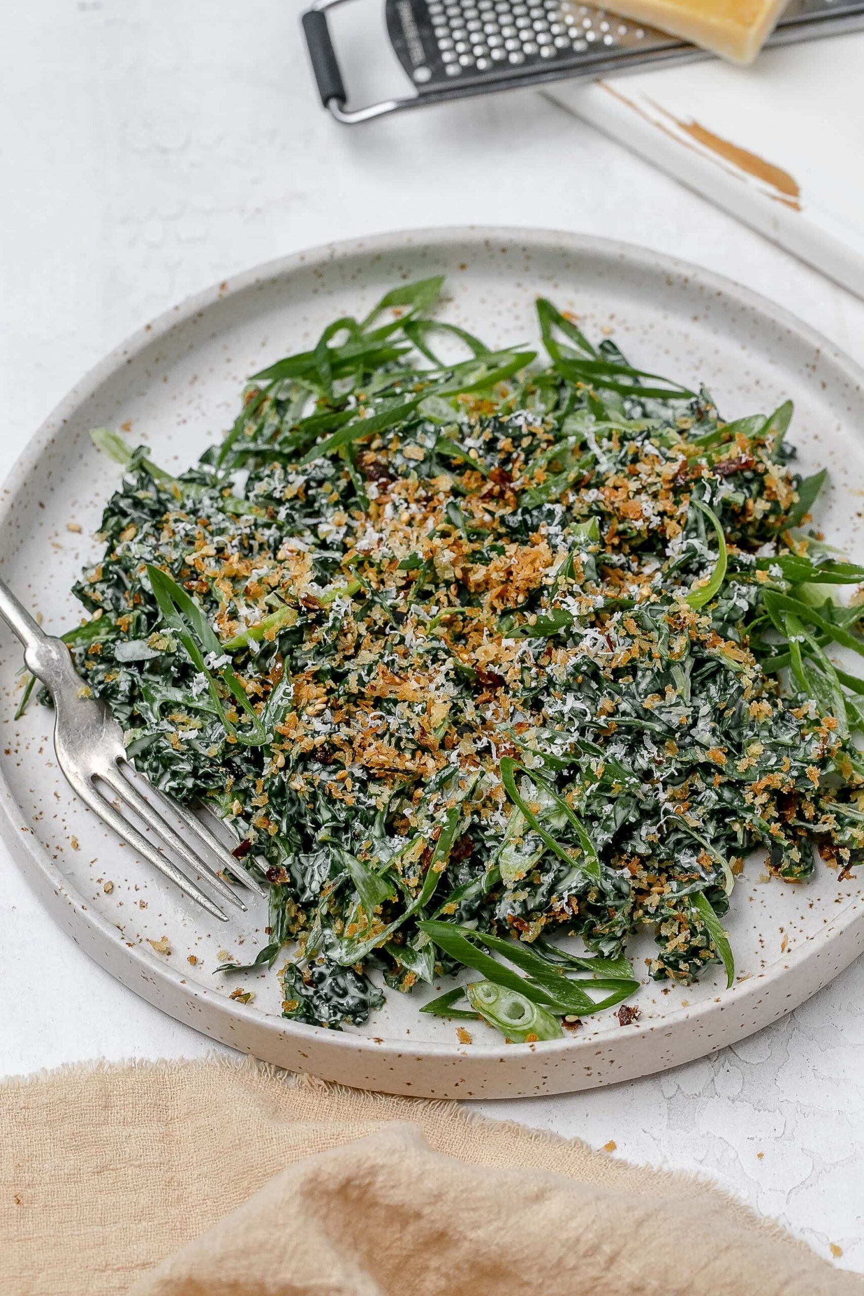 Miso kale caesar salad on a plate with a fork. 