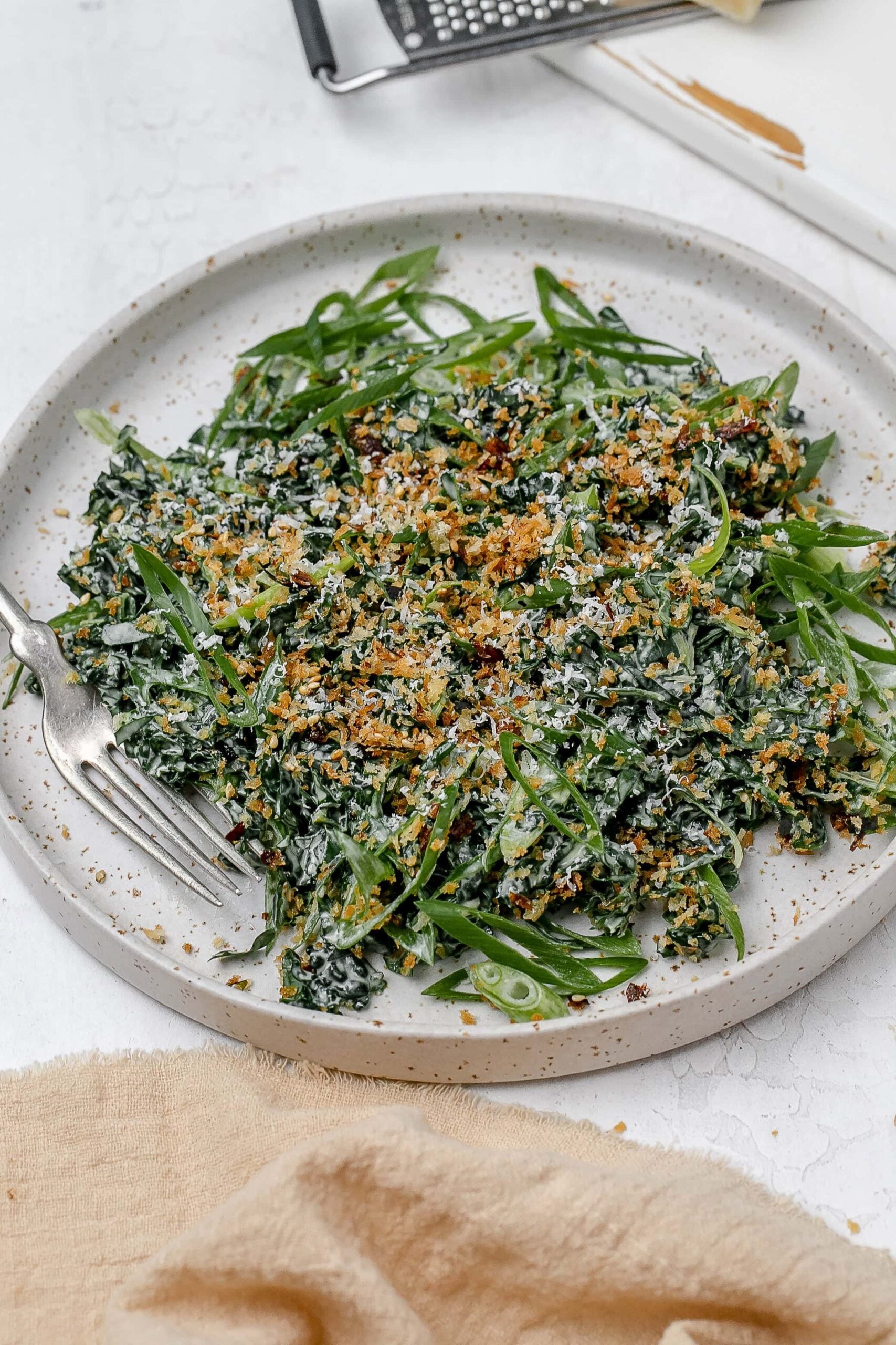 Miso kale caesar salad on a plate with a fork. 