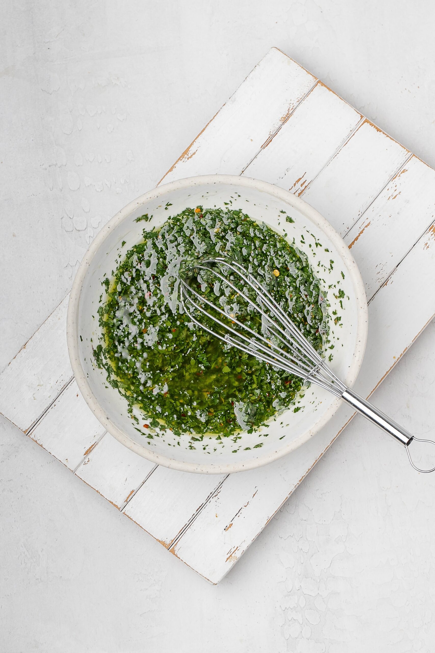 chimichurri in a bowl with a whisk.