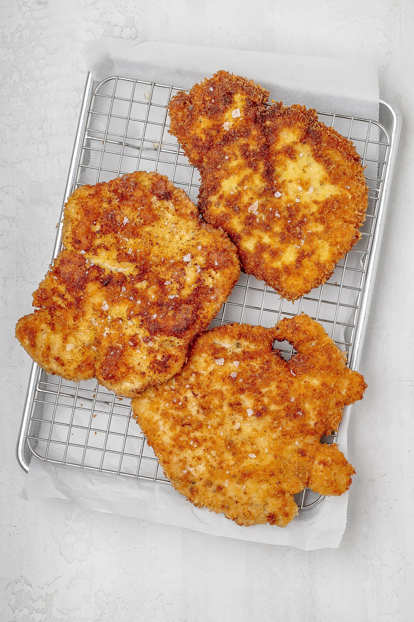 chicken cutlets pan fried on wire rack.