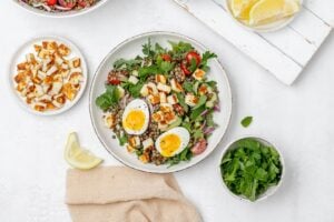 halloumi lentil salad in a bowl with a soft boiled egg on top.