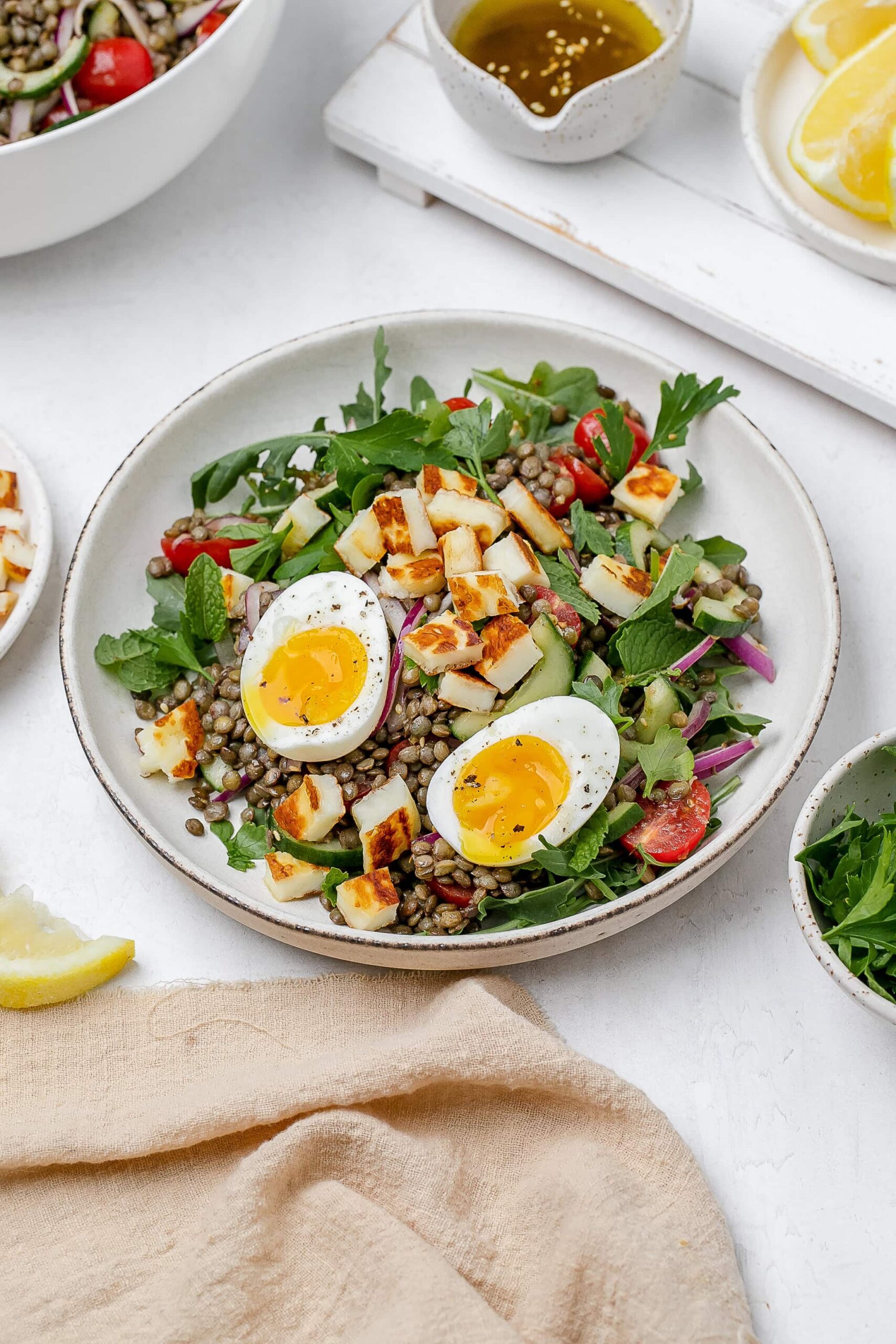 halloumi lentil salad in a bowl with a soft boiled egg on top.