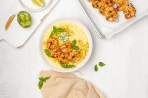 shrimp and polenta in a bowl with corn, basil and butter.