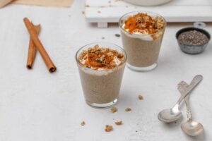 pumpkin chia seed pudding in a glass jar with toppings.