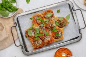meatballs with vodka sauce in slider buns with basil on top.