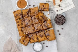 brown butter pumpkin cookie bars with chocolate chips on parchment paper.