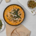 pumpkin risotto in a shallow black bowl with crispy sage, brown butter and pumpkin seeds.